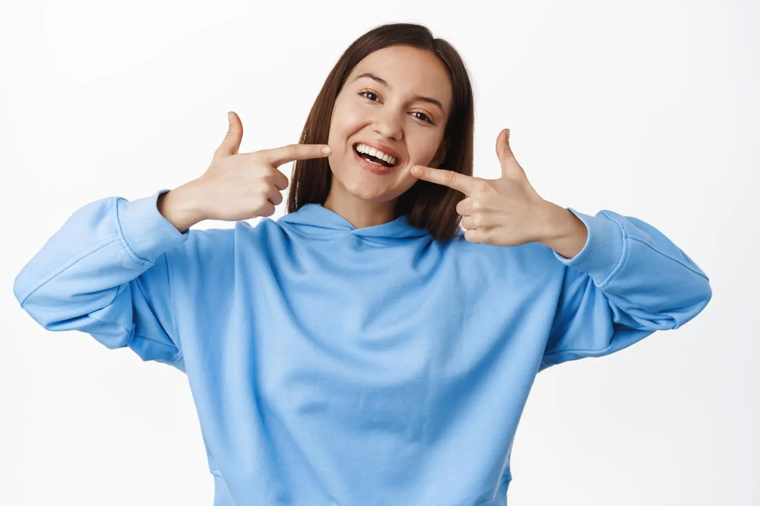 Confident young woman smiling after metal braces treatment, embracing a classic option for a perfect smile.