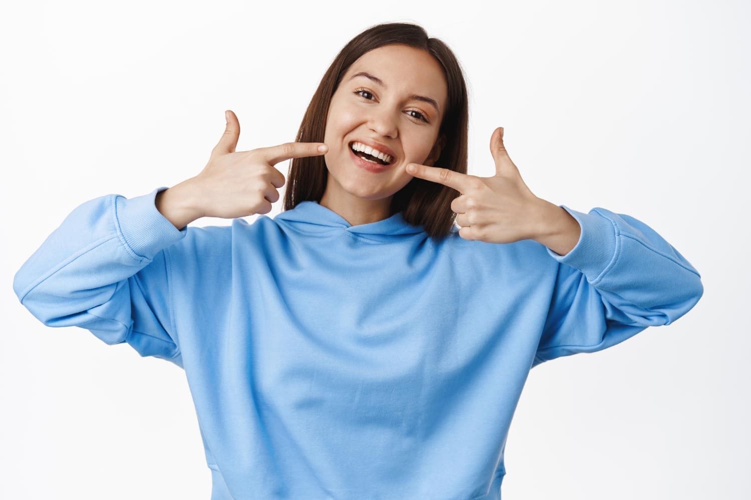 Confident young woman smiling after metal braces treatment, embracing a classic option for a perfect smile.