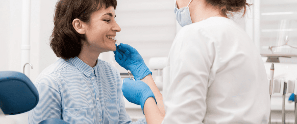 Orthodontist carefully examining a patient's teeth to monitor progress during orthodontic treatment.