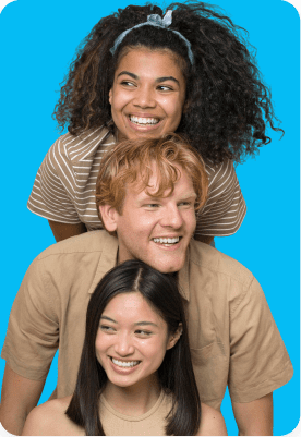 Three people are stacked in a playful pose against a blue background, all smiling and looking to the side.