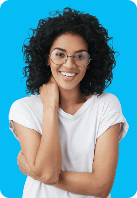 A woman with curly hair and glasses smiles, wearing a white t-shirt against a blue background.