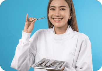 A woman in a white coat holds a dental tool and a tray of dental instruments against a blue background.